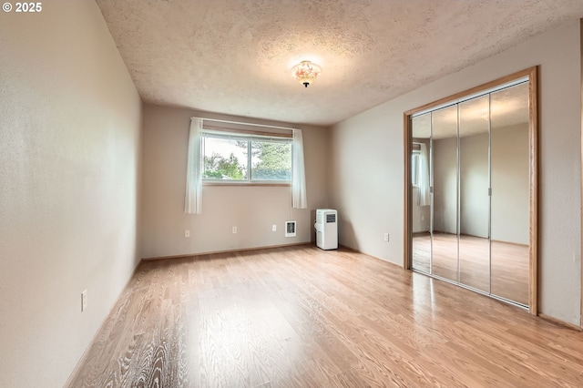 863 NE Fleming Ave Unit B-10, Gresham, OR 97030 - unfurnished bedroom with light wood-type flooring, a textured ceiling, and a closet
