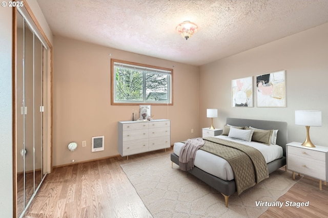 863 NE Fleming Ave Unit B-10, Gresham, OR 97030 - bedroom with light wood-type flooring, a textured ceiling, baseboards, and heating unit