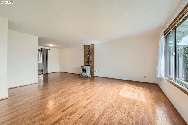 863 NE Fleming Ave Unit B-10, Gresham, OR 97030 - unfurnished living room with light wood finished floors, a wood stove, and baseboards