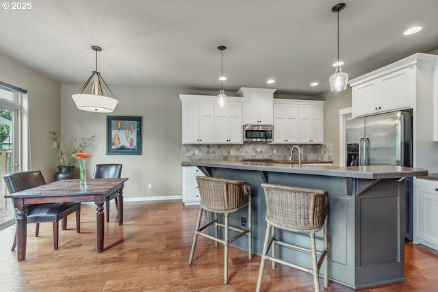 418 SW 140th Ave, Beaverton, OR 97006 - kitchen with appliances with stainless steel finishes, recessed lighting, tasteful backsplash, white cabinets, and light wood-type flooring