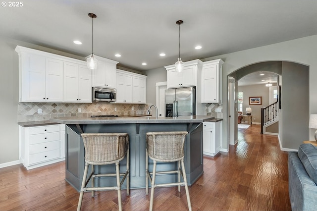 418 SW 140th Ave, Beaverton, OR 97006 - kitchen featuring stainless steel appliances, arched walkways, decorative backsplash, white cabinetry, and recessed lighting
