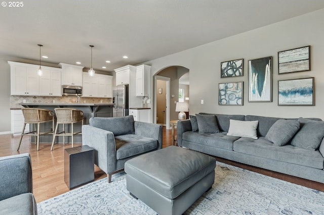 418 SW 140th Ave, Beaverton, OR 97006 - living room featuring arched walkways, recessed lighting, and light wood-style floors