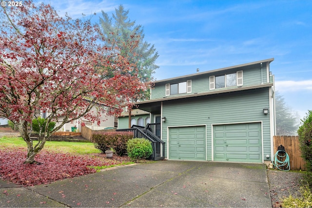 view of front facade with fence, concrete driveway, and an attached garage