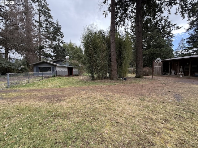 view of yard with an outdoor structure, fence, and an outbuilding