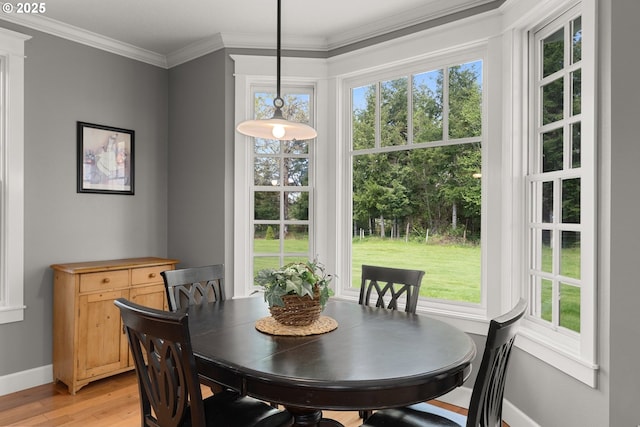 dining area featuring crown molding and light hardwood / wood-style flooring