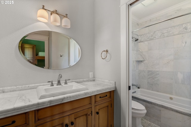 full bathroom with crown molding, toilet, vanity, and tiled shower / bath