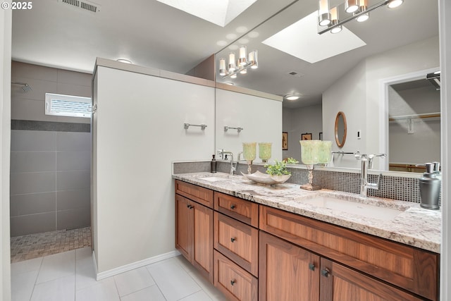 12909 SW Jacob Ct, Portland, OR 97224 - bathroom with a skylight, double vanity, a walk in shower, tile patterned flooring, and baseboards