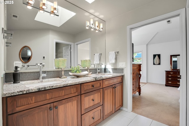 12909 SW Jacob Ct, Portland, OR 97224 - full bath featuring a skylight, double vanity, tile patterned floors, and tasteful backsplash