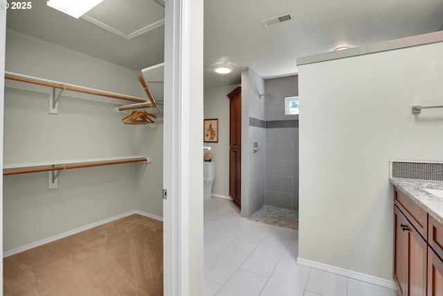 12909 SW Jacob Ct, Portland, OR 97224 - bathroom with tiled shower, vanity, a spacious closet, and toilet