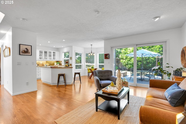 12909 SW Jacob Ct, Portland, OR 97224 - living room with light wood-style flooring, healthy amount of natural light, a textured ceiling, recessed lighting, and a chandelier