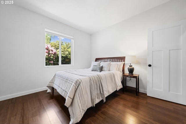 bedroom featuring baseboards and dark wood-type flooring