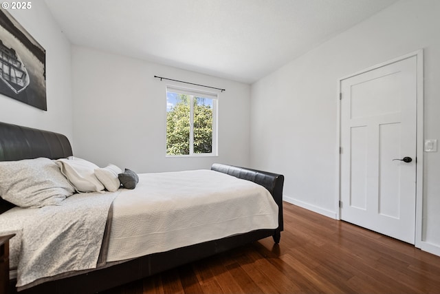 bedroom with baseboards and wood finished floors