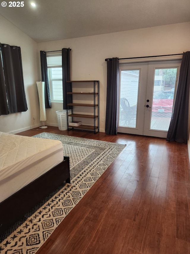 bedroom with access to outside, wood finished floors, multiple windows, and french doors