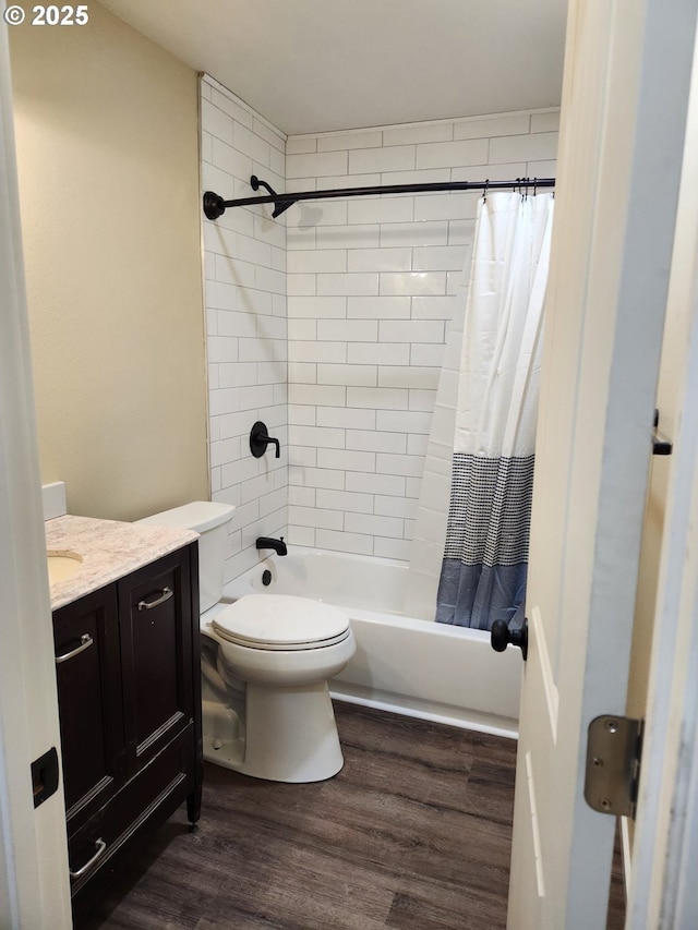 bathroom with shower / bath combo with shower curtain, toilet, wood finished floors, and vanity