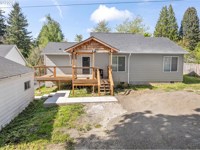 rear view of house with a deck and a shingled roof