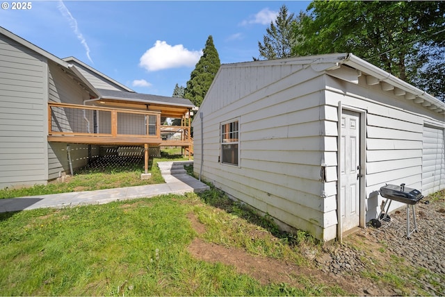 view of side of home featuring a yard and a deck