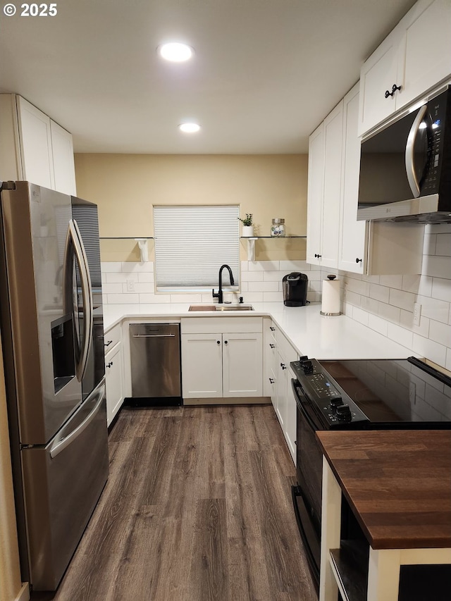 kitchen featuring a sink, appliances with stainless steel finishes, open shelves, and dark wood-style flooring