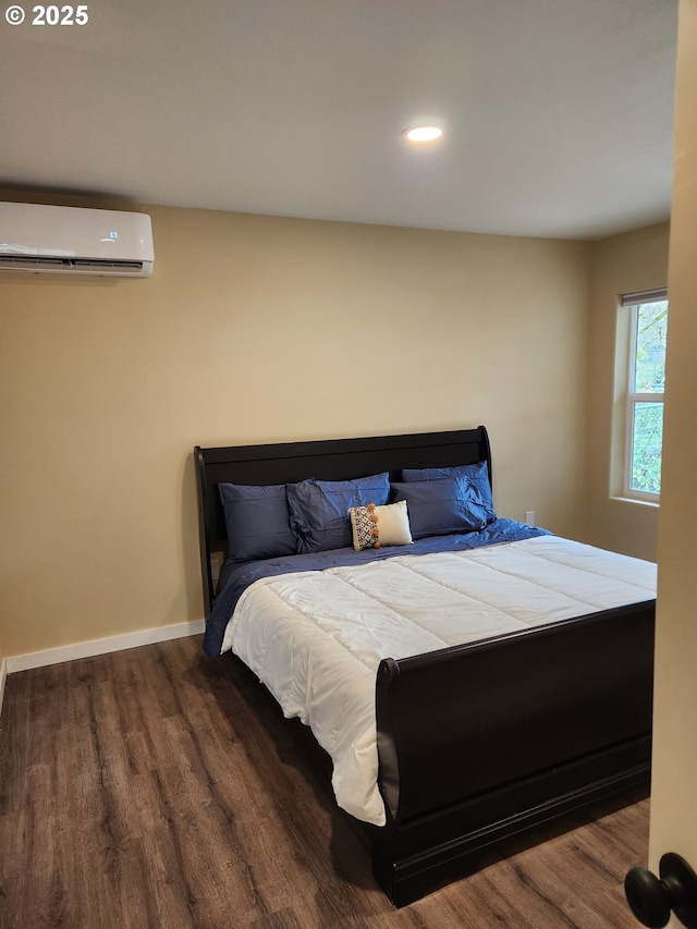bedroom with recessed lighting, baseboards, a wall mounted AC, and wood finished floors