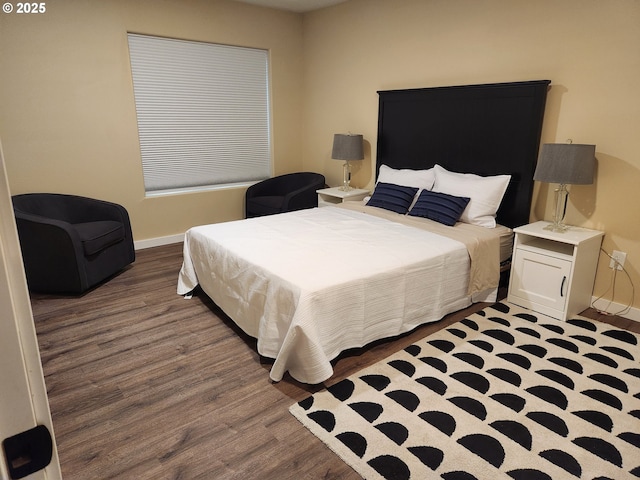 bedroom with baseboards and wood finished floors
