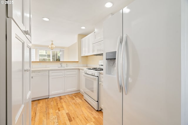 kitchen featuring light wood-type flooring, white appliances, sink, and white cabinets