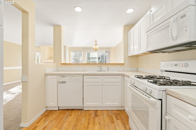 kitchen featuring white cabinetry, sink, white appliances, and a healthy amount of sunlight