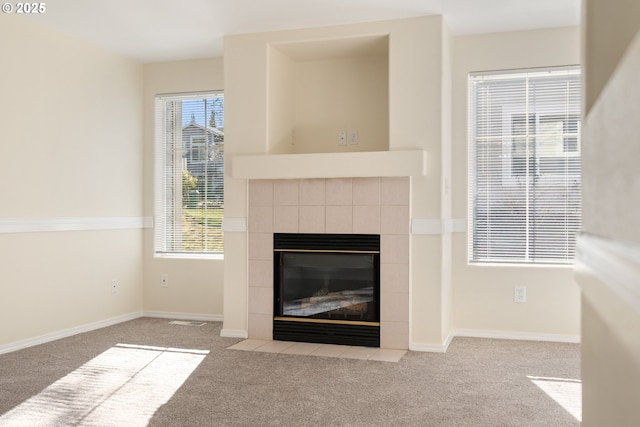 details with a tiled fireplace and carpet floors