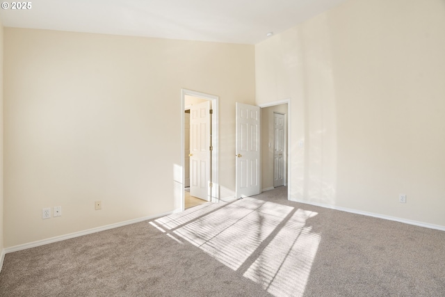 spare room with light colored carpet and high vaulted ceiling