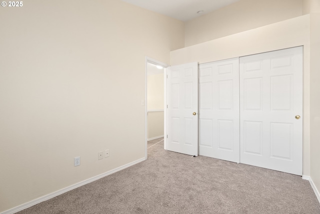 unfurnished bedroom with light carpet and a closet