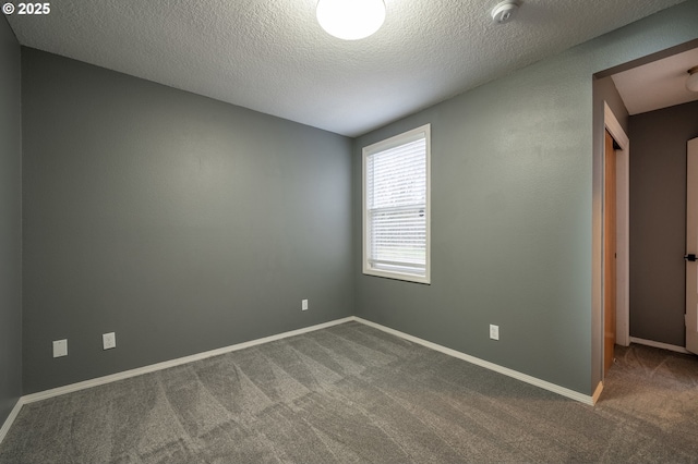 carpeted empty room with a textured ceiling and baseboards