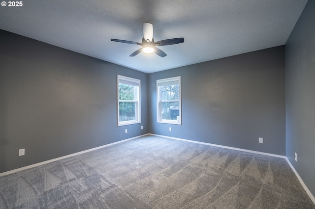 carpeted empty room featuring a textured ceiling, a ceiling fan, and baseboards