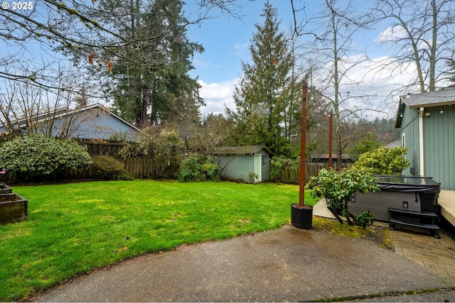 view of yard featuring an outbuilding, a patio, a hot tub, a shed, and a fenced backyard