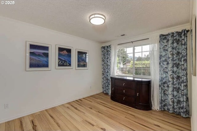 2040 Spruce Ave, Woodland, WA 98674 - unfurnished bedroom with light wood finished floors, a textured ceiling, ornamental molding, and baseboards