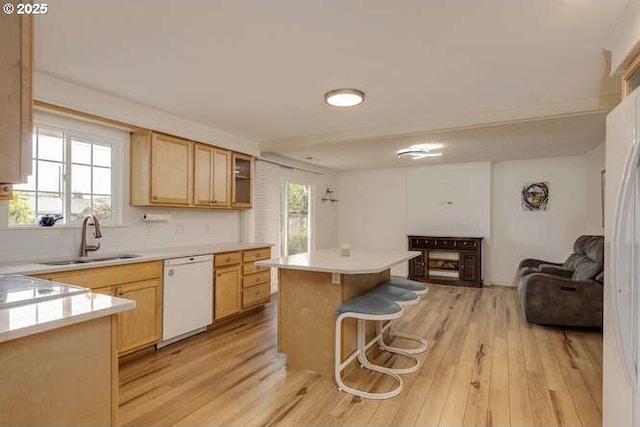 2040 Spruce Ave, Woodland, WA 98674 - kitchen featuring white dishwasher, a sink, light wood-type flooring, a kitchen island, and a breakfast bar area