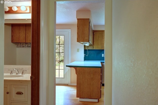 1630 SW 14th St, Warrenton, OR 97146 - kitchen featuring light wood finished floors, light countertops, and a textured ceiling
