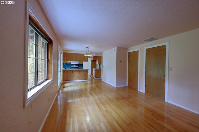 1630 SW 14th St, Warrenton, OR 97146 - unfurnished living room featuring light wood finished floors and a textured ceiling