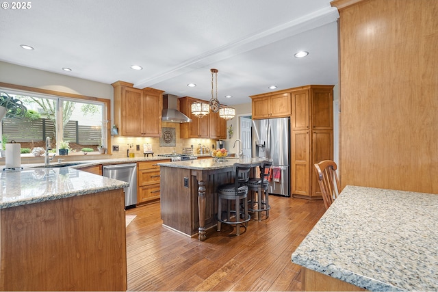 15137 SW Peachtree Dr, Portland, OR 97224 - kitchen featuring appliances with stainless steel finishes, wall chimney range hood, light stone counters, light wood-style flooring, and backsplash