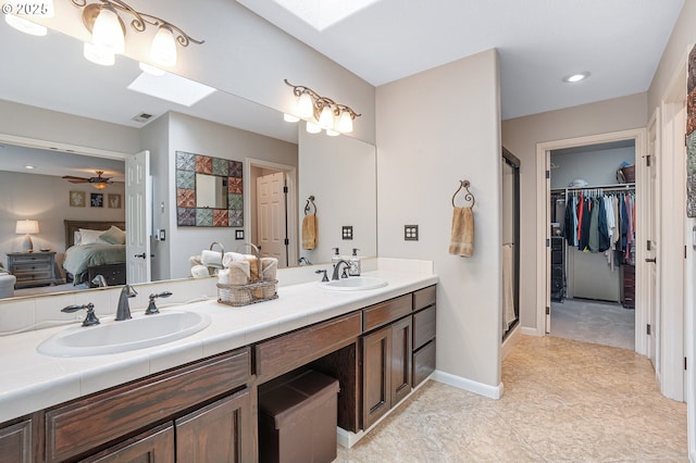15137 SW Peachtree Dr, Portland, OR 97224 - ensuite bathroom featuring a skylight, double vanity, a stall shower, and a walk in closet