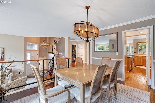 15137 SW Peachtree Dr, Portland, OR 97224 - dining area featuring a chandelier, stairs, light wood-type flooring, and crown molding