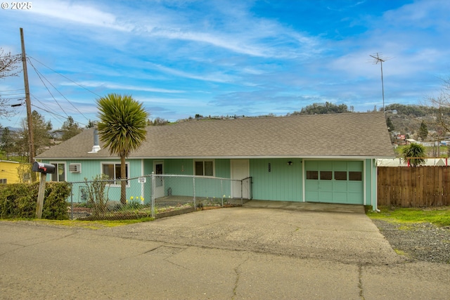 ranch-style house with a garage, a shingled roof, driveway, and fence