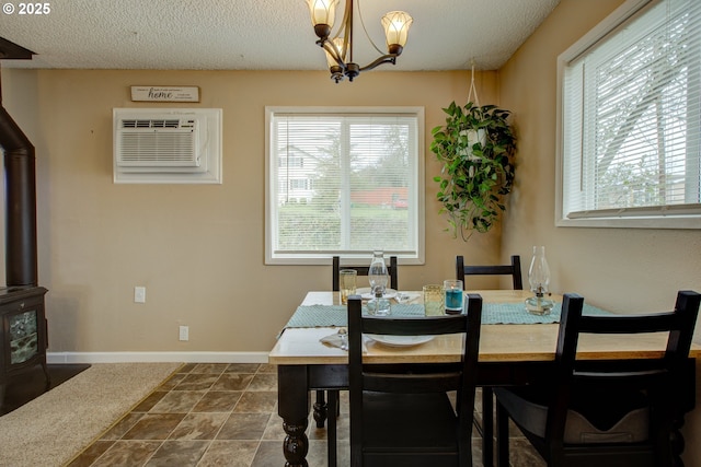 dining room with a wood stove, plenty of natural light, and a textured ceiling