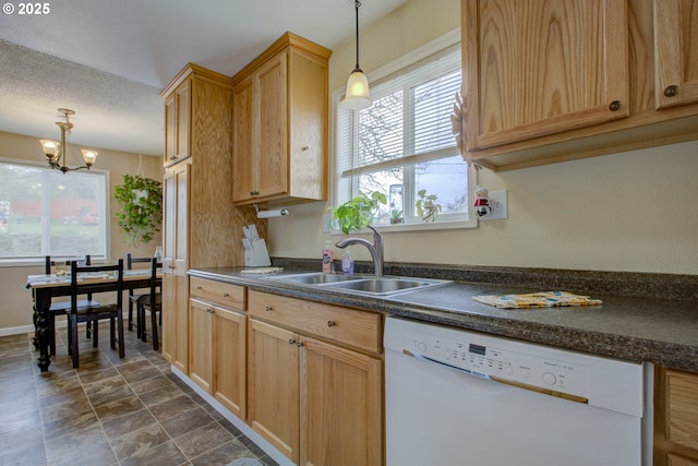 kitchen with a sink, dark countertops, dishwasher, and a healthy amount of sunlight