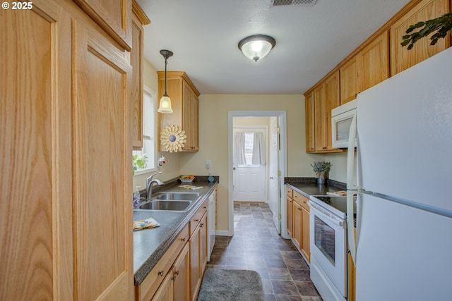 kitchen with dark countertops, baseboards, pendant lighting, white appliances, and a sink