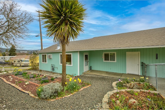 view of front of house with a shingled roof and fence