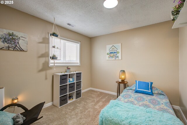 bedroom with visible vents, carpet floors, a textured ceiling, and baseboards