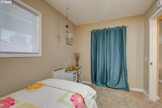 bedroom featuring baseboards, carpet floors, and a textured ceiling