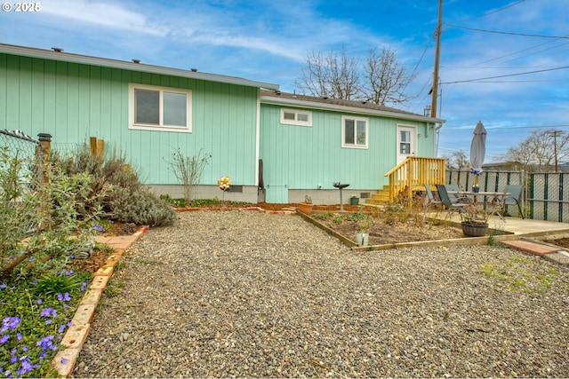 back of property with crawl space, a vegetable garden, and fence