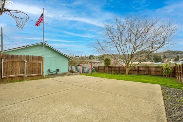 view of basketball court featuring a lawn and a fenced backyard