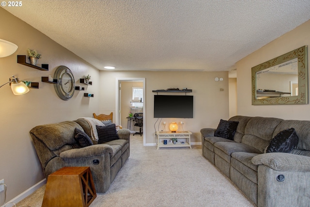 living area featuring light colored carpet, a textured ceiling, and baseboards