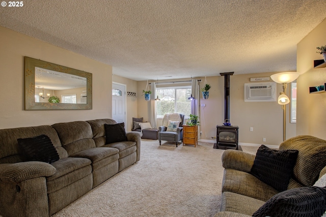 carpeted living area featuring a wood stove, baseboards, a wall mounted air conditioner, and a textured ceiling