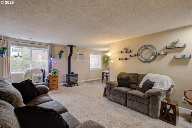 carpeted living area with a textured ceiling, a wood stove, baseboards, and a wall mounted AC